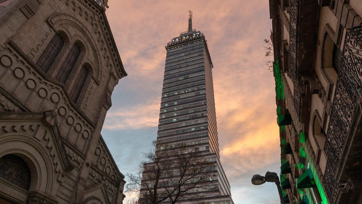 The Torre Latinoamericana rising above a Mexico City street at sunset.