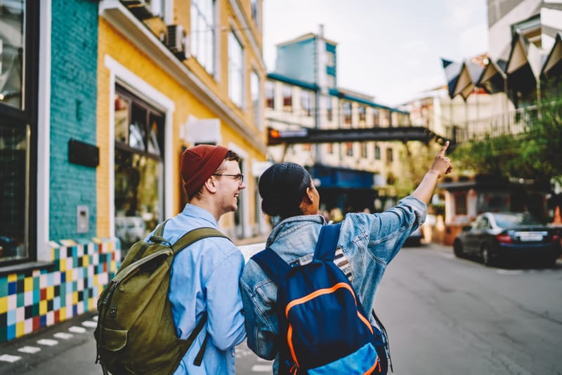 Two backpackers exploring a city street.